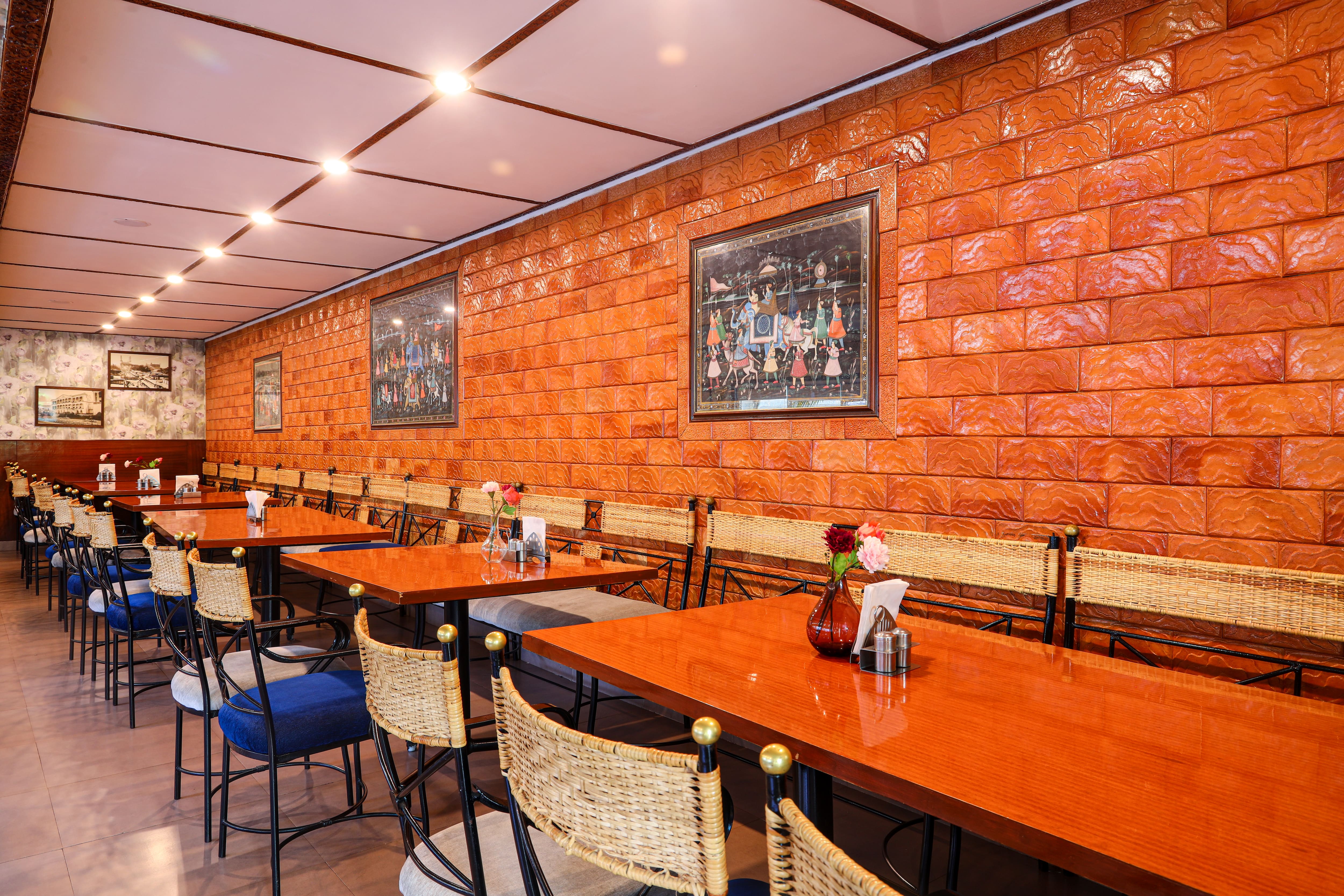 Brick wall art and set tables at The Spicy Venue